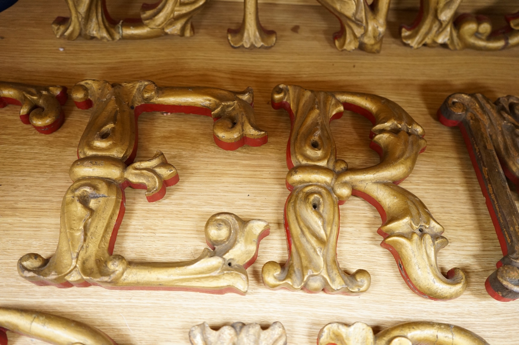 A quantity of decorative carved, painted and gilt carnival letters, each approximately 23cm high